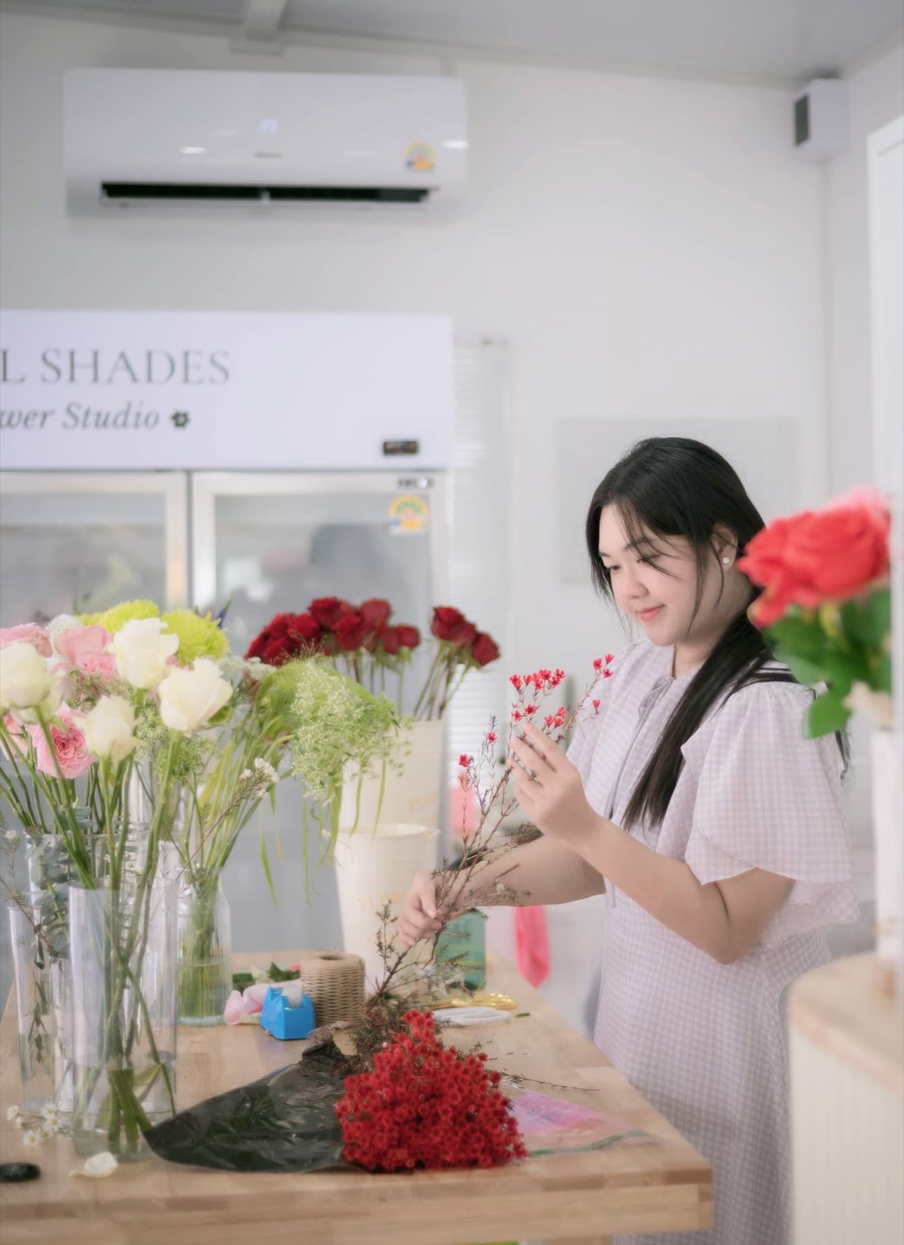 A Petal Shades florist tying a bouquet by hand